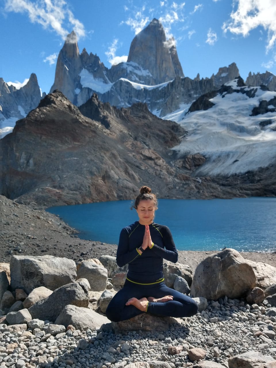Femme méditant en pleine nature dans un paysage paisible, pratiquant la méditation pour le bien-être mental et la pleine conscience.